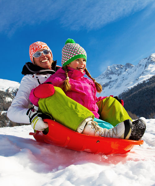 Una mamma gioca sulla neve con il figlio